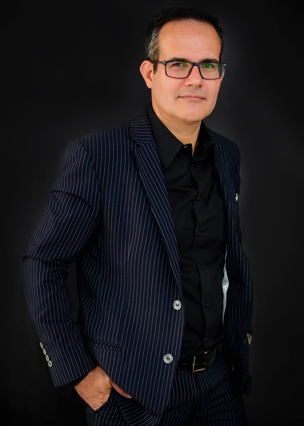 Dr. Rodrigo Schenckel, advogado, em pé com terno risca de giz